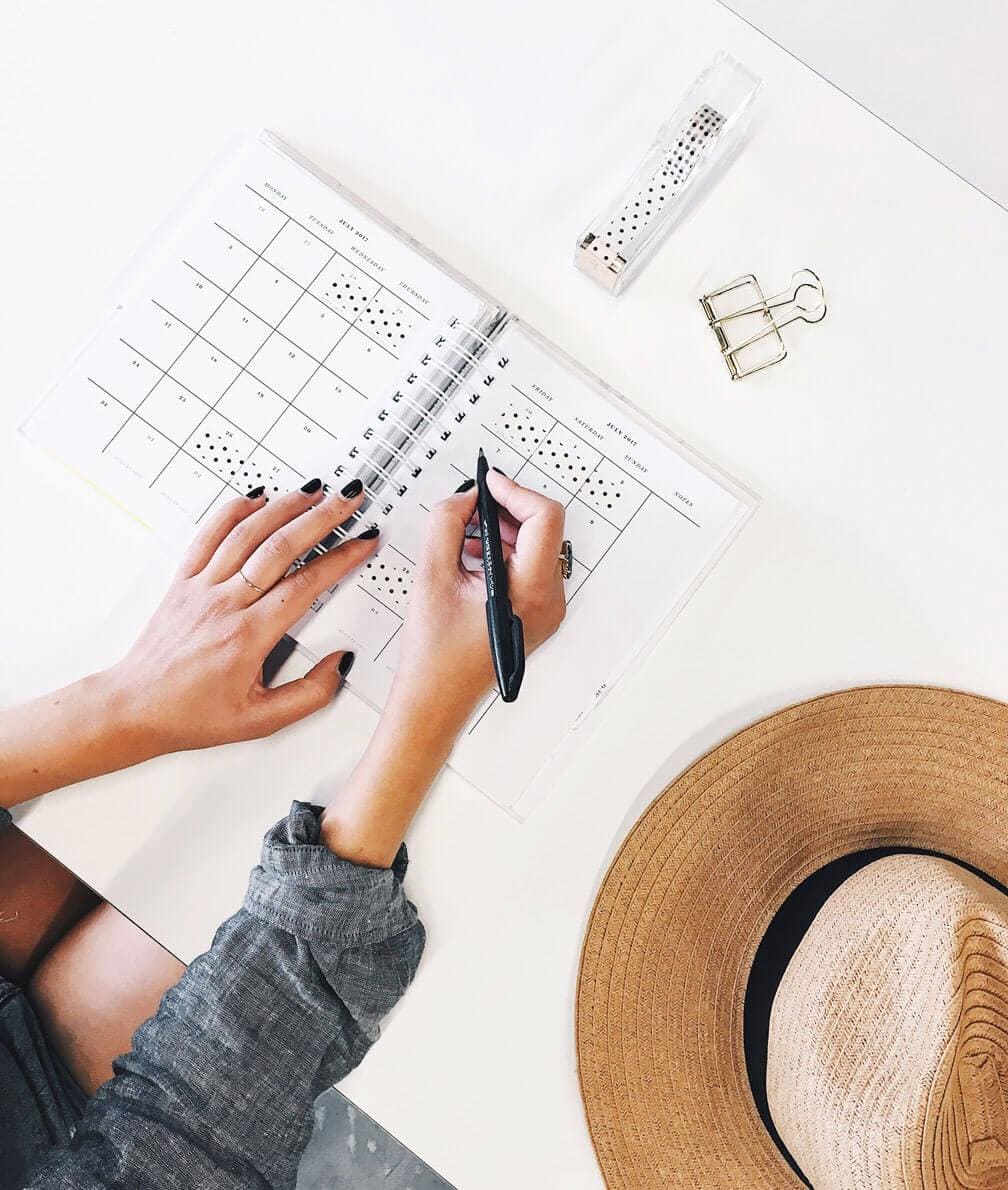 Scheduler-2 Person scheduling an appointment in an agenda.